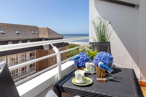 einen Tisch auf einem Balkon mit Meerblick in der Unterkunft Duen12_45 in Westerland