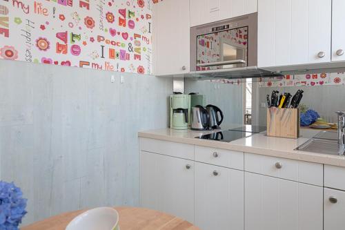 eine Küche mit weißen Schränken und einer Arbeitsplatte in der Unterkunft Duen12_45 in Westerland