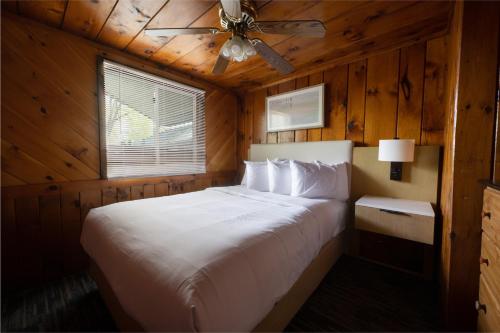 a bedroom with a bed with a ceiling fan at Depe Dene Lakeside Resort in Lake George