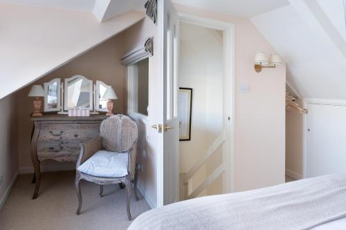 a bedroom with a bed and a desk with a chair at Enchanting Harbourside Cottage with Panoramic Views in Polruan