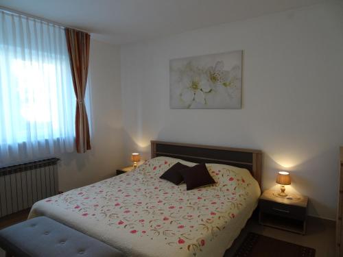 Un dormitorio con una cama con flores. en Apartman Jelena, en Zagreb