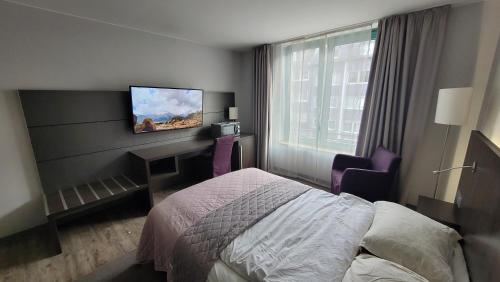 a hotel room with a bed and a tv on the wall at Nice Apartment in modern Center of Düsseldorf in Düsseldorf