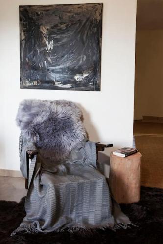 a furry chair sitting under a painting on a wall at Bezeniko Amazing Arcadian Property! in Vlakhérna