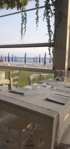 a table with chairs and a view of the beach at Appartamento Marina D’Ardea vista mare in Ardea
