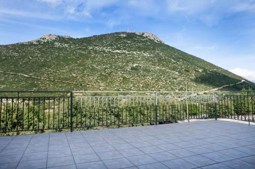 a view of a hill with a fence and a mountain at Bezeniko Amazing Arcadian Property! in Vlakhérna