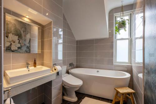 uma casa de banho com uma banheira, um WC e um lavatório. em Luxury Central Home - Parking & EV point em Canterbury
