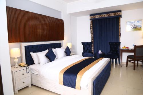 Premier Inn Express Gulberg Lahore في لاهور: غرفة نوم بسرير كبير وطاولة وكراسي