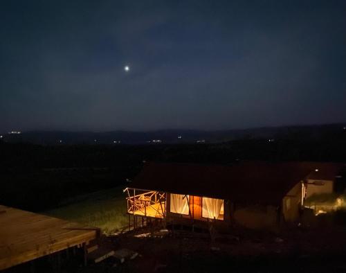 a house at night with the moon in the sky at TERRA - Saturnia tented lodges in Saturnia