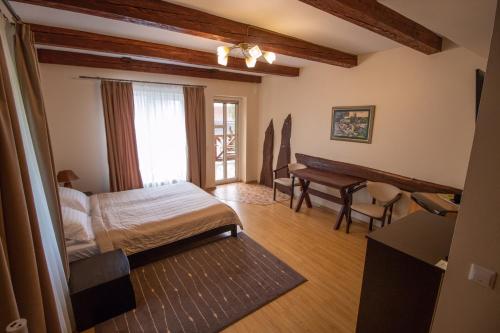 a bedroom with a bed and a desk in a room at Veres in Yaremche