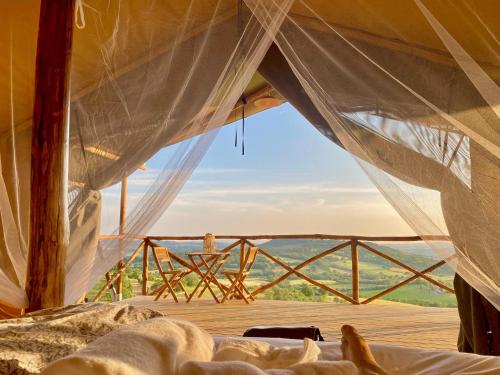 a bed in a tent with a view at TERRA - Saturnia tented lodges in Saturnia