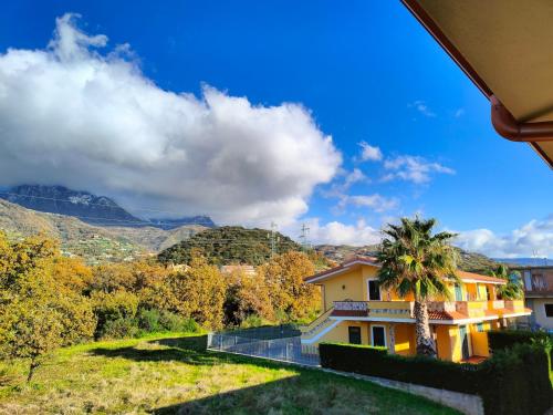 une maison sur une colline avec un palmier dans l'établissement Przytulny apartament w Belvedere Marittimo, à Belvedere Marittimo
