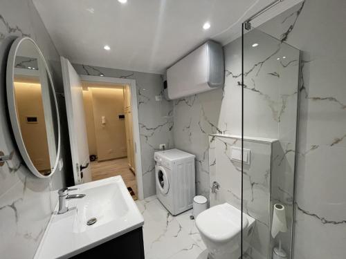 een badkamer met een wastafel, een toilet en een douche bij City center Apartment 1 in Tirana