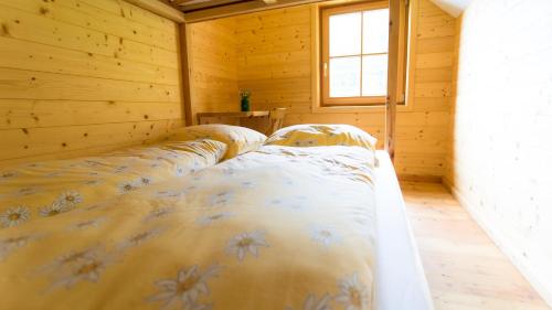 a bedroom with a bed in a wooden room at Stranighütte in Obervellach