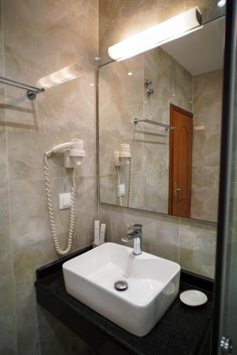a bathroom with a white sink and a mirror at Kostas Beach Apartments in Agios Gordios