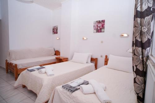 a room with two beds with towels on them at Kostas Beach Apartments in Agios Gordios
