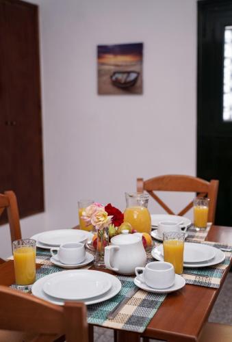 a table with plates and glasses of orange juice at Kostas Beach Apartments in Agios Gordios