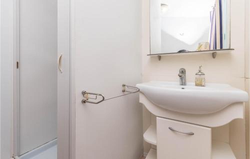 een witte badkamer met een wastafel en een spiegel bij Beautiful Home In Turanj With Wifi in Turanj