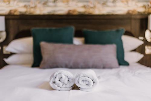 two towels sitting on top of a bed at The Bull Hotel in Stony Stratford