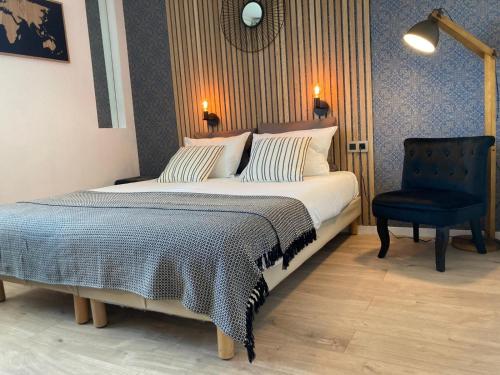 a bedroom with a large bed and a blue chair at Appart'Hotel - Gare TGV - Courtine - Confluence - 407 in Avignon