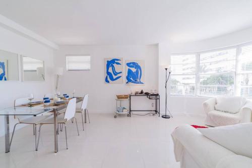 a white living room with a table and chairs at 2 BEDROOM ON THE BEACH ! in Miami Beach
