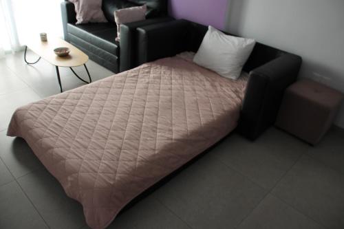 a large bed in a room with a couch at Beautiful apartment near beach in Larnaca in Scala