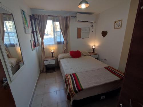 - une petite chambre avec un lit et un miroir dans l'établissement El apartamento de Teddy, à San Miguel de Tucumán