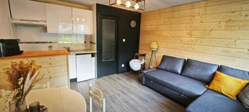 un salon avec un canapé bleu et une cuisine dans l'établissement Studio Cosy le Malicieux, à Saint-Lary-Soulan