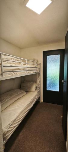 une chambre avec deux lits superposés et une fenêtre dans l'établissement Studio Cosy le Malicieux, à Saint-Lary-Soulan