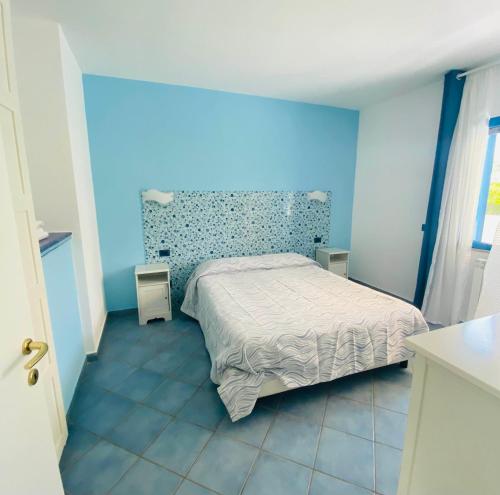 a bedroom with a bed in a blue room at Residenza Le Spiagge in Sperlonga