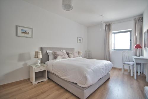 ein weißes Schlafzimmer mit einem Bett und einem Schreibtisch in der Unterkunft Luxury Apartment 90sqm with Pool near Beach WIFI Unlimited Optical Fiber in Agadir