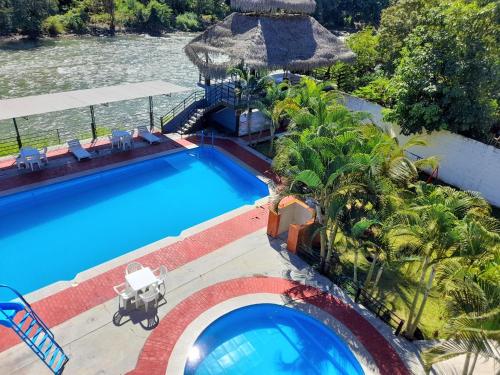 an overhead view of a swimming pool with palm trees at Hotel Rupa Rupa in San Ramón