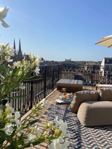 een balkon met banken en uitzicht op de stad bij Hôtel Singulier Bordeaux in Bordeaux
