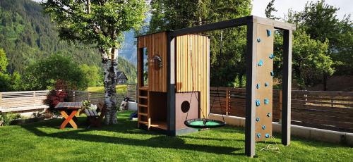 a play structure in a yard with a playground at Appartements-Pension Lindenheim in Schladming