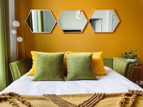 a bedroom with a bed with three mirrors above it at Vintage Vibes - Minutes From The Broadway Buzz in Nashville