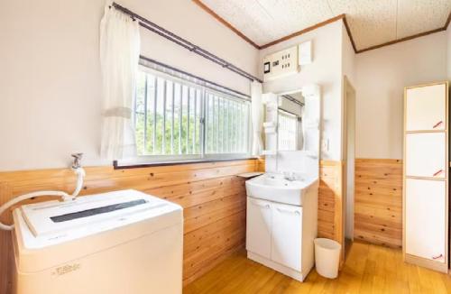 uma casa de banho com um lavatório e uma máquina de lavar roupa em ウッドペッカーC棟 em Nasu