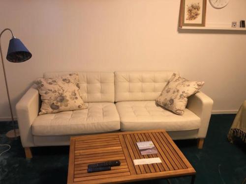 a living room with a white couch and a coffee table at Österlen - Skillinge in Skillinge