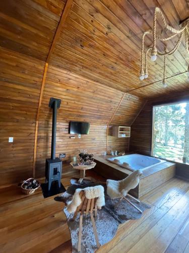 a living room with a tub in a wooden cabin at Cabana Paradouro da Serra in Cambará