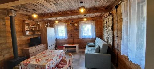 a living room with a table and a couch and a table and a chair at ORYNKA chatka w Malinnikach in Malinniki