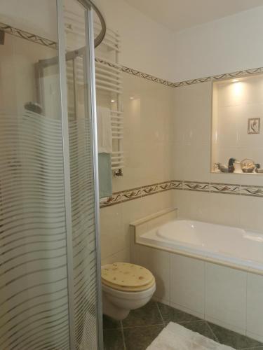 een badkamer met een toilet, een bad en een wastafel bij Green Apple Guesthouse in Leányfalu