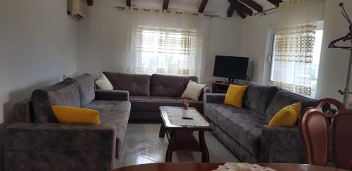 a living room with a couch and a tv at Guest House Ilir in Berat