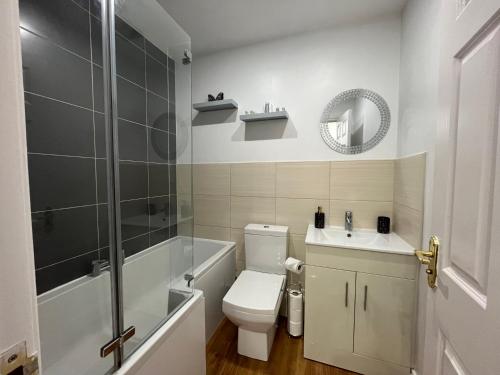 a bathroom with a toilet and a sink and a shower at The Heathers - Spacious 3 Bed, Home from Home in Burton in Burton upon Trent