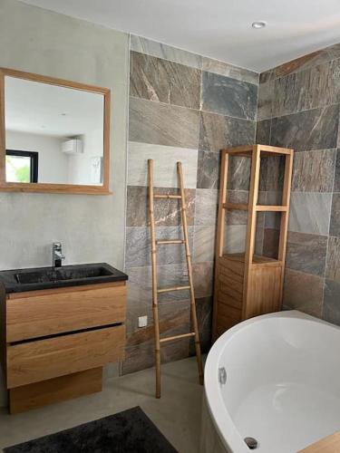 une salle de bain avec une baignoire, un lavabo et un miroir dans l'établissement Villa haut de gamme 160 M2 Piscine chfé et Jacuzzi, à Aigues-Mortes