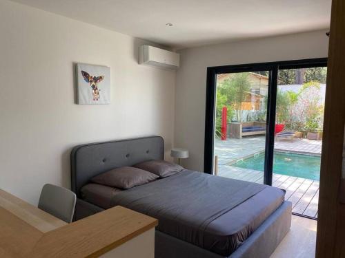 - une chambre avec un lit et une porte donnant sur une piscine dans l'établissement Villa haut de gamme 160 M2 Piscine chfé et Jacuzzi, à Aigues-Mortes
