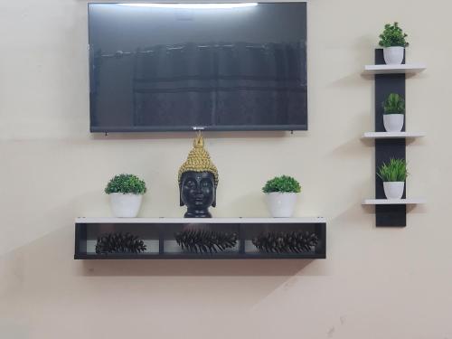 a tv on a wall with a statue on it at Dhairya's Villa Home Away From Home in Jammu