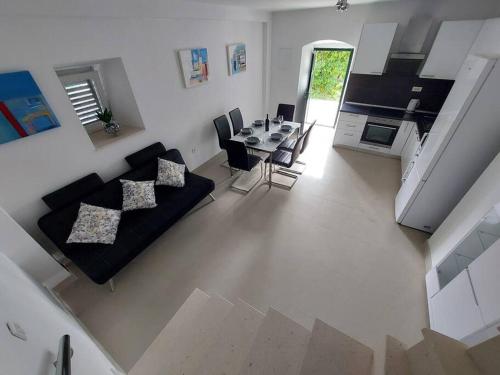 a living room with a black couch and a table at Orange Tree House in Šipanska Luka