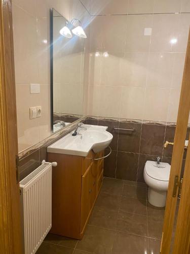 a bathroom with a sink and a toilet and a mirror at Rocas Brancas in Ribadeo