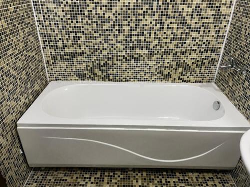 W wyłożonej kafelkami łazience znajduje się biała wanna. w obiekcie апартамент в Сарафово w Burgas