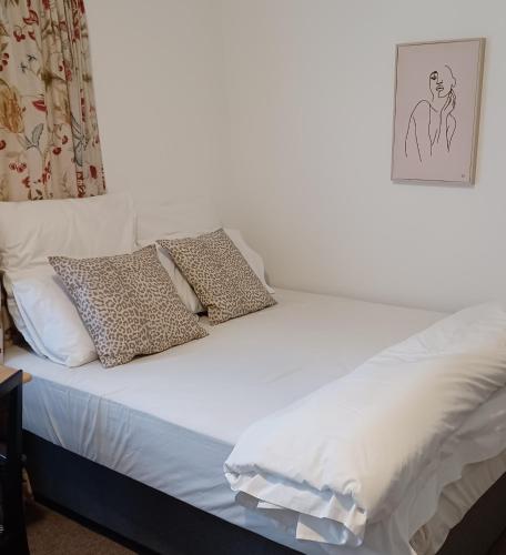 un letto bianco con due cuscini sopra di Craighall Park Stylish Garden Studio a Johannesburg
