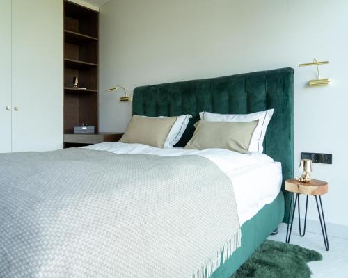sypialnia z dużym łóżkiem z zielonym zagłówkiem w obiekcie Vila MonRai 