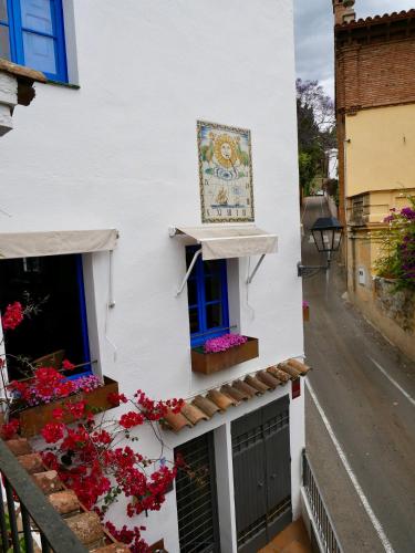 a white house with flowers on the side of it at Hostal de la Plaça - Hotel Boutique in Cabrils